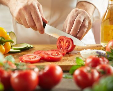 Chef cutting tomatoes
