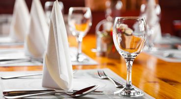 Table prepared with glasses, spoons and napkins